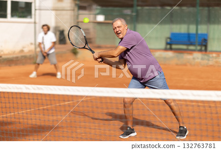 Two men playing lawn tennis outdoors Two men playing lawn tennis outdoors 132763781