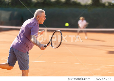Elderly man playing tennis 132763782