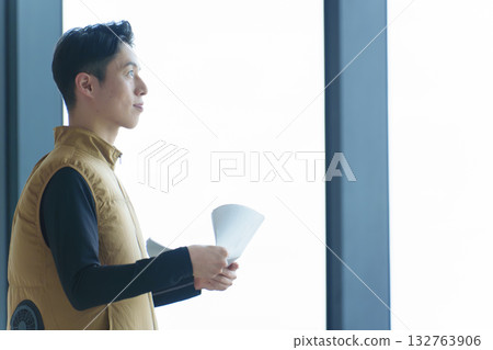 一名穿著風扇背心的工人正在檢查圖紙 132763906