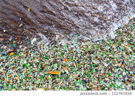 Colorful sea glass and ceramic fragments on the shore of Glass Bay, Vladivostok, Russia. Smooth pieces sparkle in the waves of the Japanese Sea. Colorful sea glass and ceramic fragments on the shore of Glass Bay, Vladivostok, Russia. Smooth pieces sparkle in the waves of the Japanese Sea. 132763956