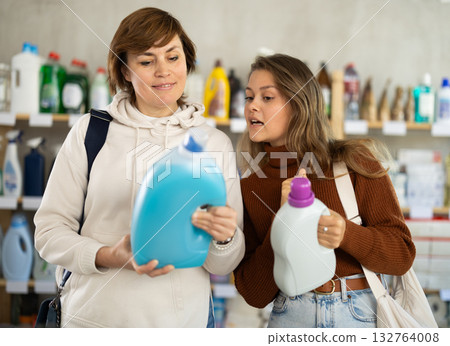 Mother and her adult daughter choose detergent together in household supermarket 132764008