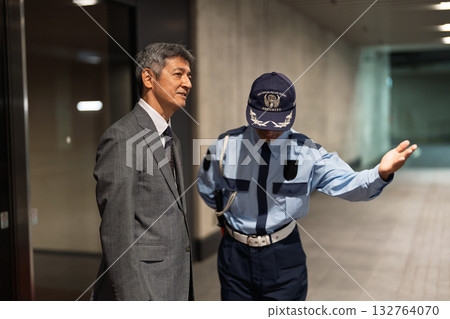 保安和商人在大樓前交談 保安和商人在大樓前交談 132764070