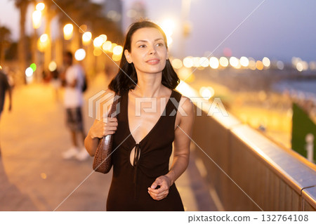 At night, girl walk at embarkment, spend time near beach in Barceloneta 132764108