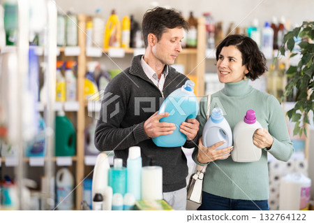 Couple man and woman choosing detergent in store Couple man and woman choosing detergent in store 132764122