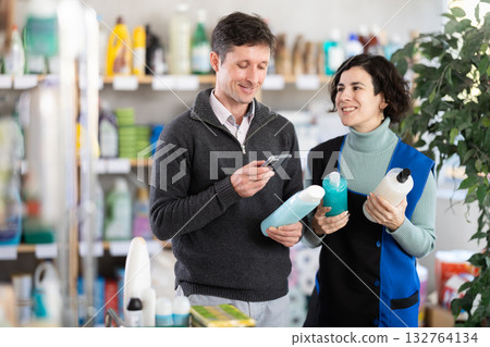 woman advises a man on the choice of shampoo woman advises a man on the choice of shampoo 132764134