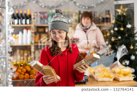 Teen girl selects suitable product from nougat assortment 132764141