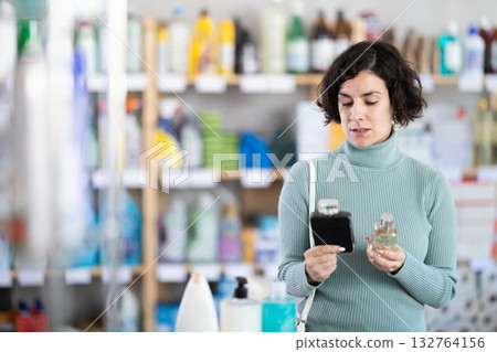 Adult woman chooses perfume in store Adult woman chooses perfume in store 132764156