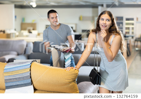 Newlyweds choose upholstered furniture in store 132764159