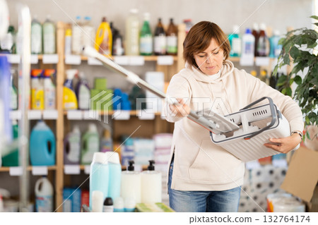 Adult woman chooses mop in store 132764174