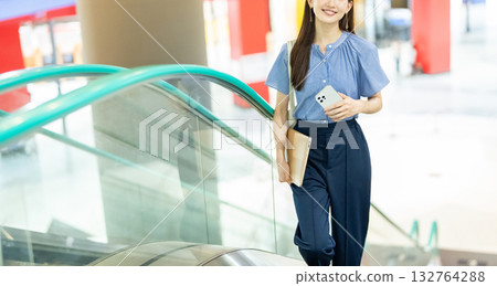 Business woman riding escalator 132764288