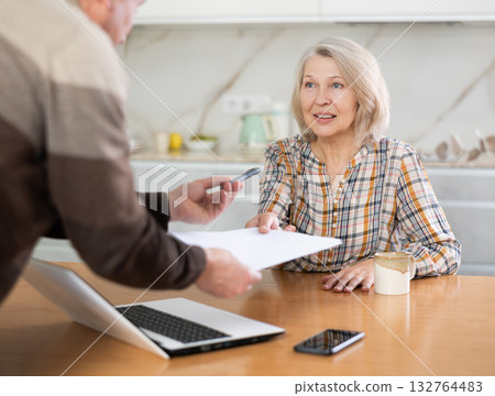 Old woman considering offer from agent 132764483