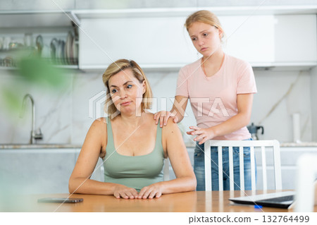 Teenage daughter cheers and encourages mother, upset by sudden bad news. 132764499