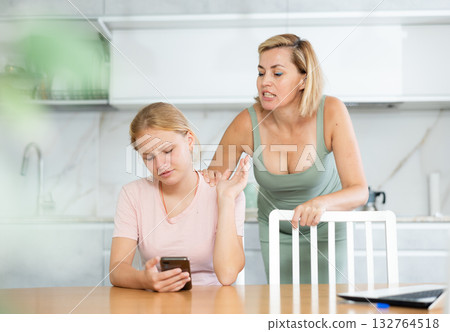 Mother scolds teenage girl for wasting time and sticking in phone. Gadgets and family Mother scolds teenage girl for wasting time and sticking in phone. Gadgets and family 132764518