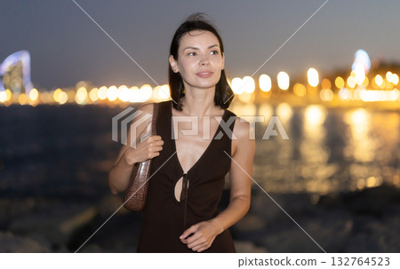 Young woman standing at seaside against background of twin towers 132764523