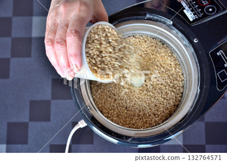 Putting brown rice into a home rice polisher 132764571