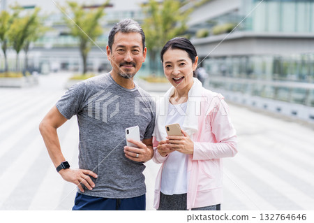 一對夫婦一邊慢跑一邊看智慧型手機 132764646