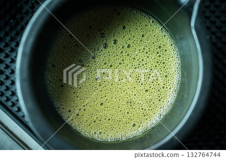 Close up of the surface of Matcha green tea drink. Close up of the surface of Matcha green tea drink. 132764744
