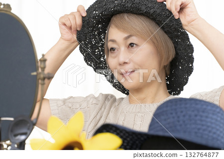 夏季外出時，老年婦女會選擇帽子和太陽眼鏡來保護自己免受紫外線傷害。 132764877