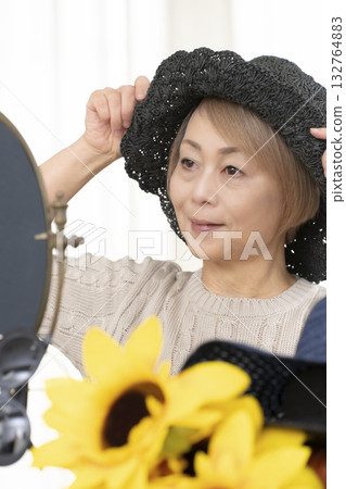 夏季外出時，老年婦女會選擇帽子和太陽眼鏡來保護自己免受紫外線傷害。 132764883