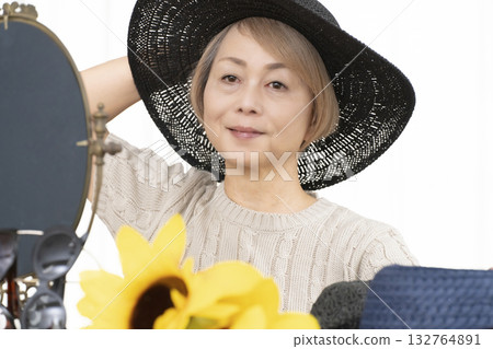 夏季外出時,老年婦女會選擇帽子和太陽眼鏡來保護自己免受紫外線傷害。 夏季外出時,老年婦女會選擇帽子和太陽眼鏡來保護自己免受紫外線傷害。 132764891