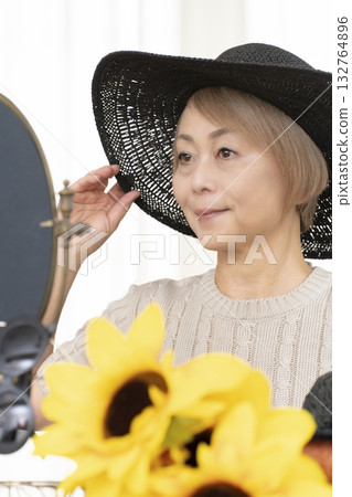 夏季外出時，老年婦女會選擇帽子和太陽眼鏡來保護自己免受紫外線傷害。 132764896