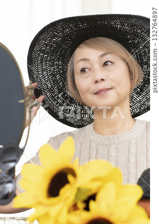 夏季外出時，老年婦女會選擇帽子和太陽眼鏡來保護自己免受紫外線傷害。 132764897