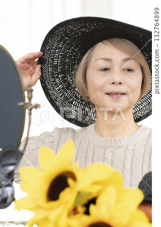 夏季外出時,老年婦女會選擇帽子和太陽眼鏡來保護自己免受紫外線傷害。 夏季外出時,老年婦女會選擇帽子和太陽眼鏡來保護自己免受紫外線傷害。 132764899