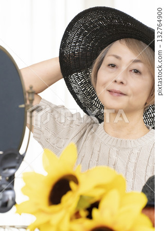 夏季外出時，老年婦女會選擇帽子和太陽眼鏡來保護自己免受紫外線傷害。 132764900