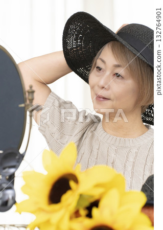 夏季外出時，老年婦女會選擇帽子和太陽眼鏡來保護自己免受紫外線傷害。 132764901