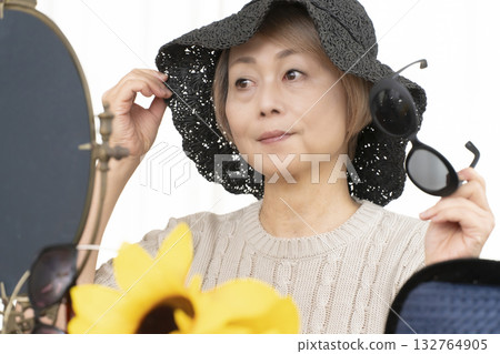 夏季外出時，老年婦女會選擇帽子和太陽眼鏡來保護自己免受紫外線傷害。 132764905