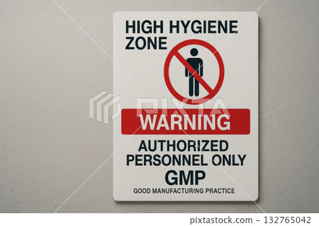 Cautionary warning sign on an industrial wall for high hygiene zone. GMP signage indicates entry restriction, allowing only authorized personnel into facility 132765042