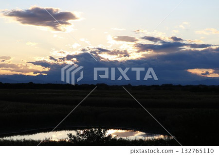 A river illuminated by the setting sun: A quiet autumn scene 132765110