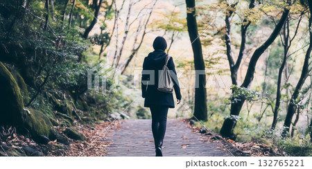 Young dark-haired woman walking through the forest 132765221