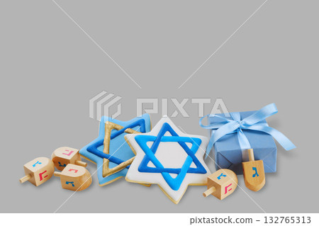 Hanukkah symbols with cookies and dreidels by a gift 132765313