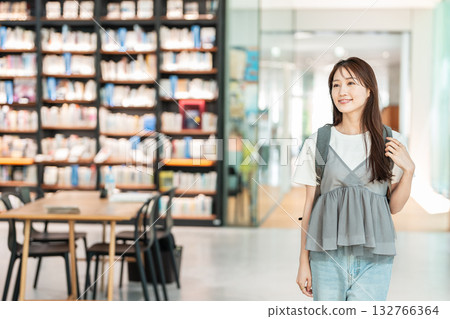 Young woman looking for a book in the library 132766364