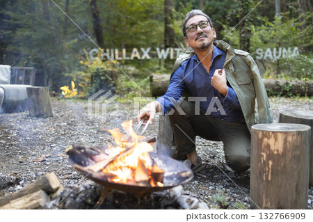 A man bonfire at a campsite A man bonfire at a campsite 132766909