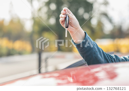 Woman's hand holding car keys. Close up. Female hand holds a car key. 132768121