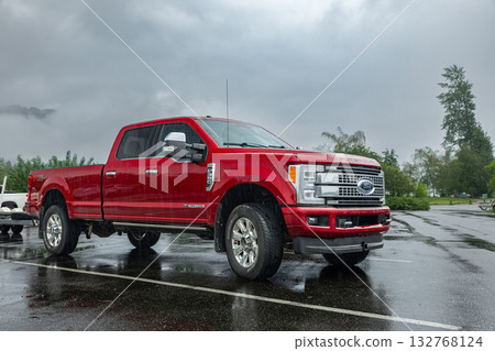 Red Ford F350 Platinum pick up truck parked on the parking lot in the rural on a rainy day. Red Ford F350 Platinum pick up truck parked on the parking lot in the rural on a rainy day. 132768124