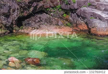 A flowing rocky river, green water of mountain river stream A flowing rocky river, green water of mountain river stream 132768412