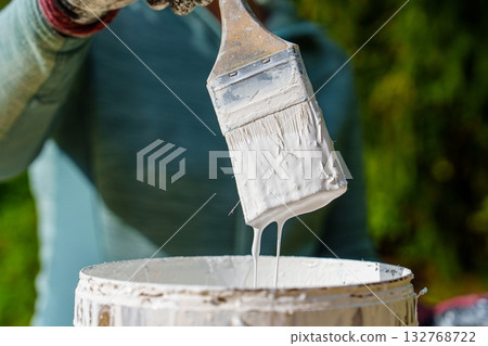 Painter Dipping Brush into Paint Can, Preparing for Home Improvement Projects 132768722