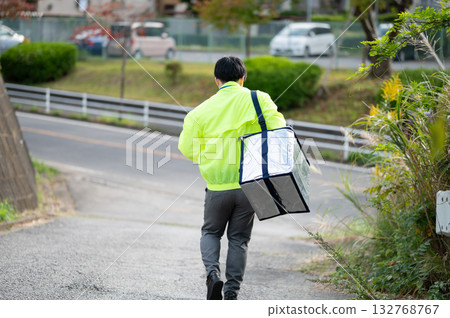 一位商人扛著冷藏箱行走 132768767