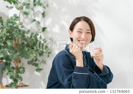 Woman in pajamas eating dessert 132769065