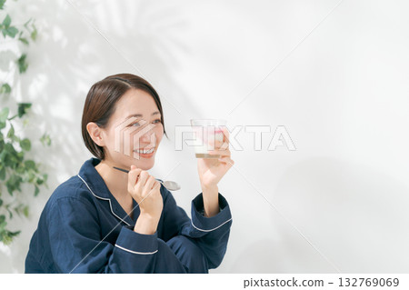 穿著睡衣的女人在吃甜點 穿著睡衣的女人在吃甜點 132769069
