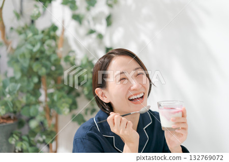 Woman in pajamas eating dessert Woman in pajamas eating dessert 132769072