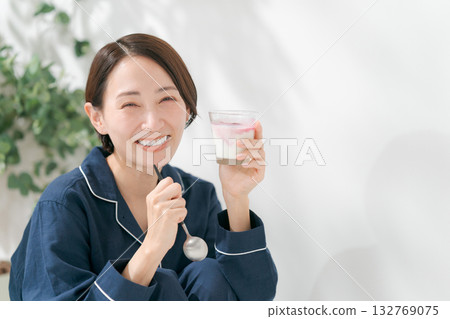 Woman in pajamas eating dessert 132769075