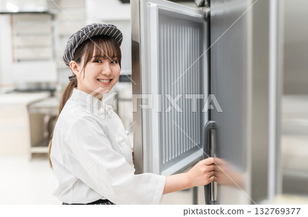 一位身穿廚師服的女廚師從冰箱取出食材 132769377