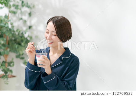 Woman in pajamas eating dessert 132769522