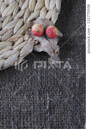 Oak apples on oak leaves. Lying on a placemat. On a rough linen burlap background. Oak apples on oak leaves. Lying on a placemat. On a rough linen burlap background. 132770506