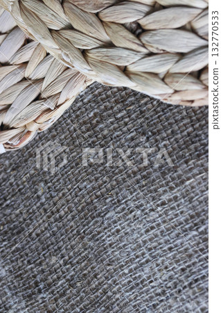 Two placemats made of water hyacinth on rough linen burlap. Close-up. 132770533