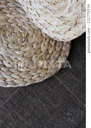 Two placemats made of water hyacinth on rough linen burlap. Two placemats made of water hyacinth on rough linen burlap. 132770534